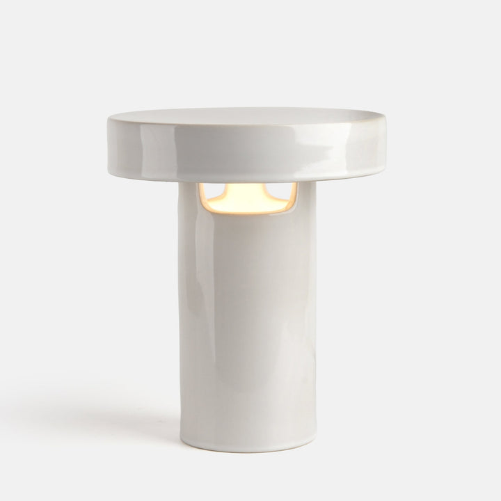 White ceramic table lamp with minimalist design and warm glow, featuring clean lines and modern aesthetic